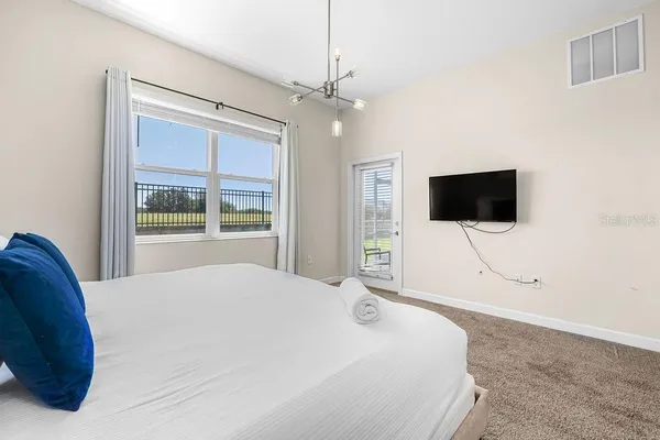 a bedroom with a bed tv and a window