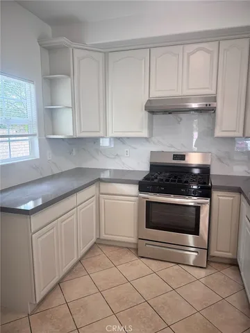 a kitchen with granite countertop white cabinets and appliances