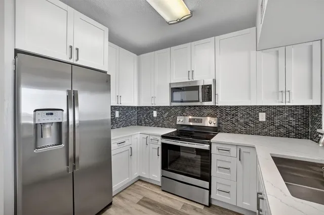 a kitchen with cabinets stainless steel appliances and sink