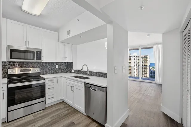 a kitchen with stainless steel appliances granite countertop a stove and a sink