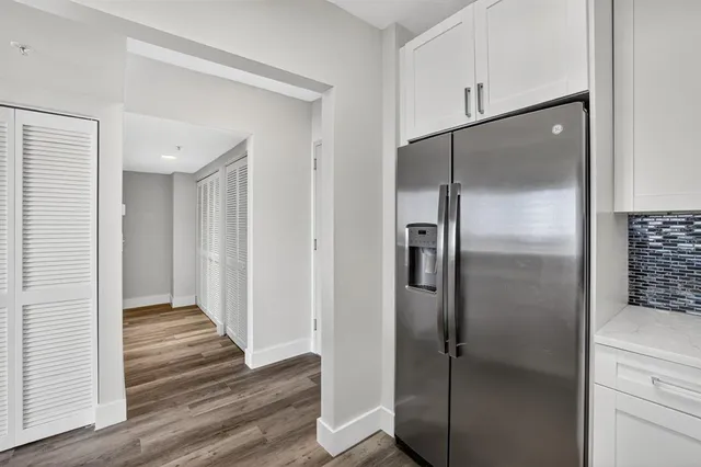 a view of a kitchen with wooden floor and electronic appliances