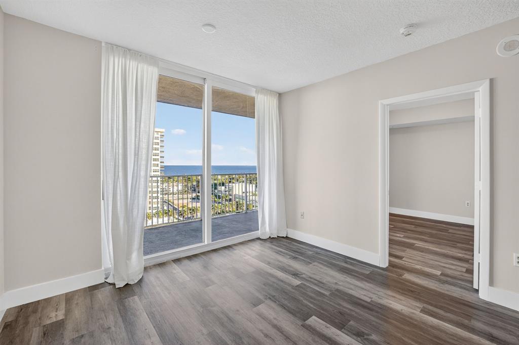 3020 Northeast 32nd Avenue, Unit 1207 Fort Lauderdale, FL 33308 - Photo 9 of 69 an empty room with wooden floor and windows