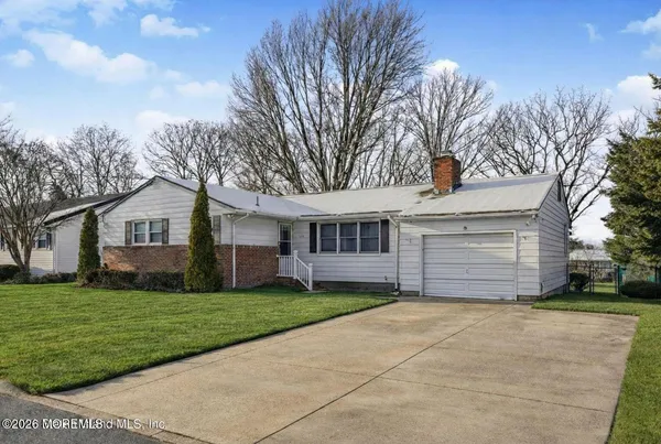 a front view of house with yard and trees