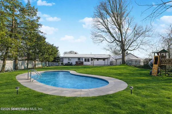 a view of a house with a swimming pool and yard
