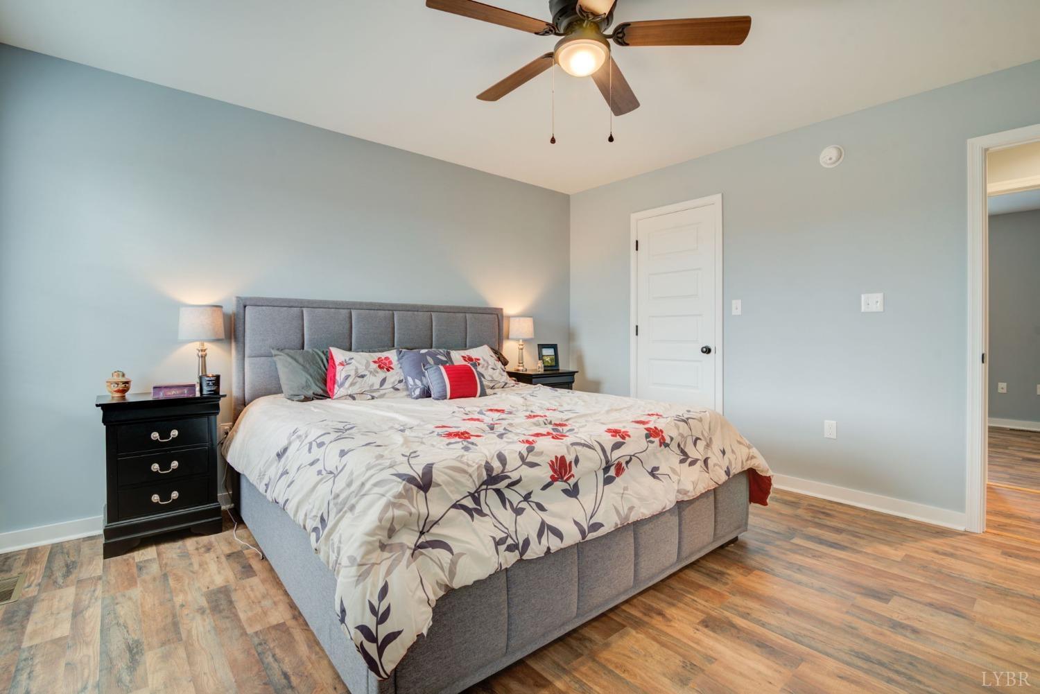701 Winfall Road Rustburg, VA 24554 - Photo 22 of 38 a bedroom with a large bed and a chandelier