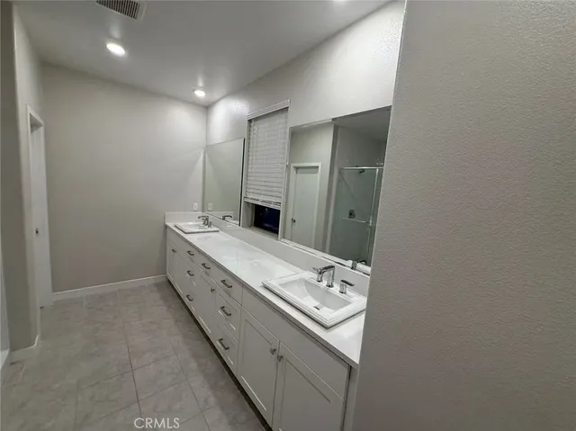 a bathroom with a double vanity sink and mirror