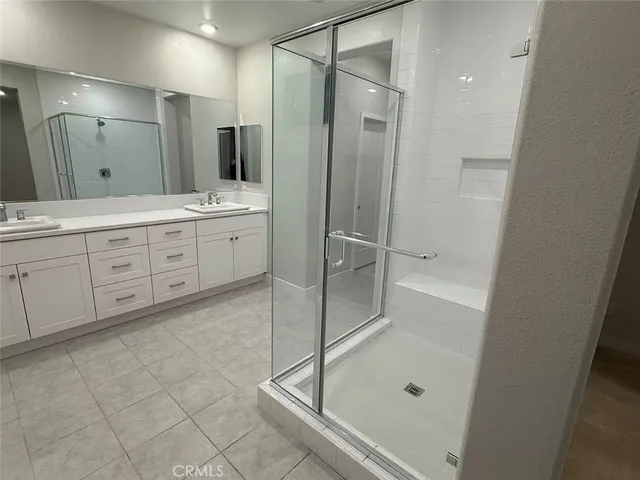 a spacious bathroom with a shower sink and mirror