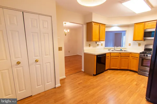 a view of an empty room with a window and hardwood floor