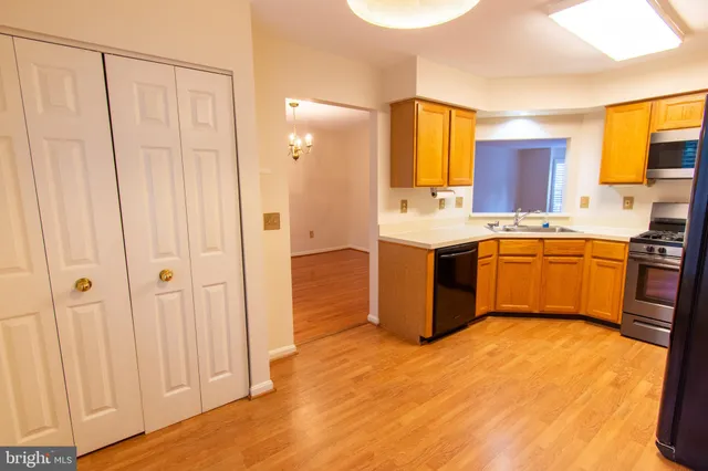 a view of an empty room with a window and hardwood floor
