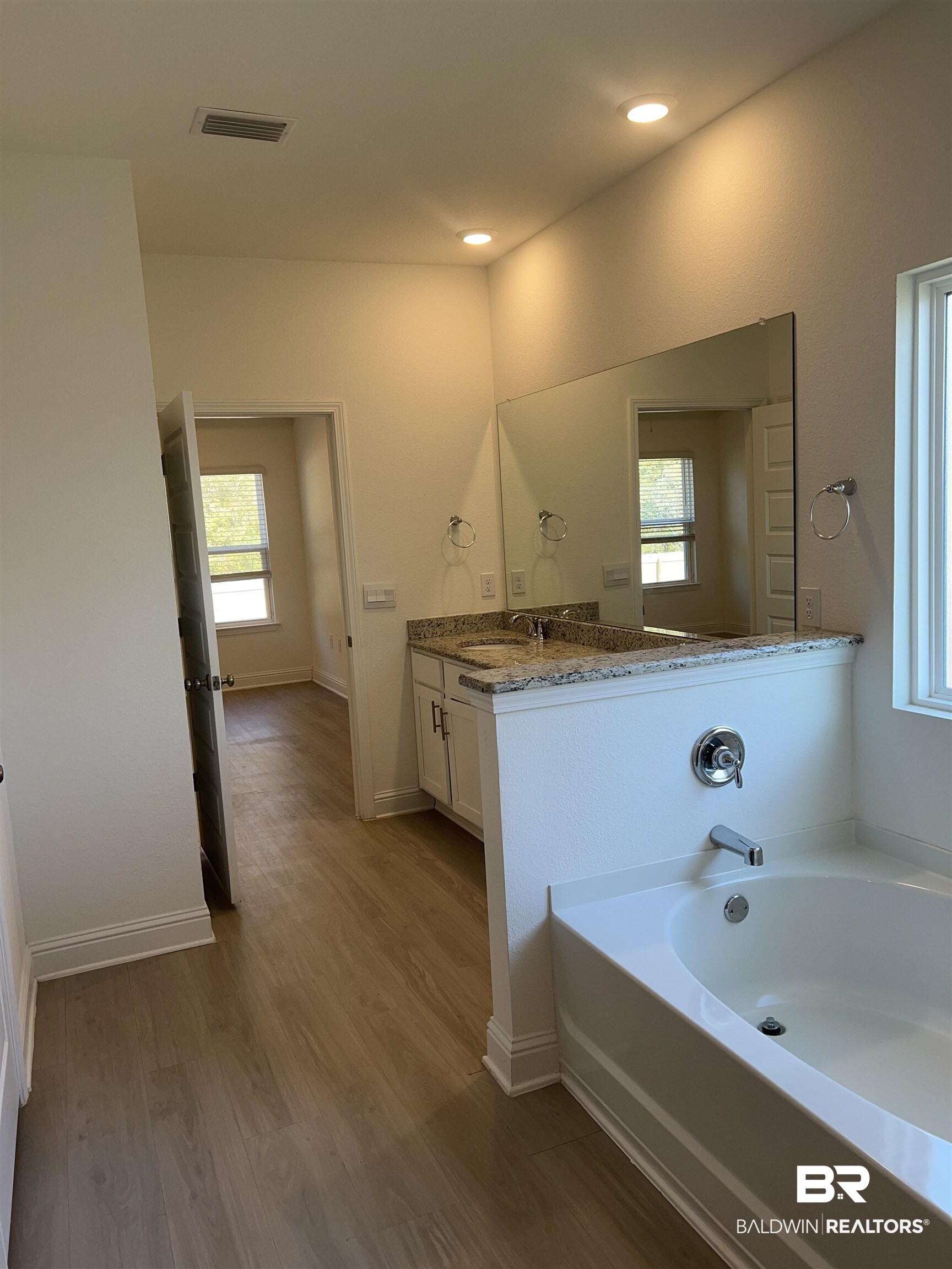 8855 Calverton Street Foley, AL 36535 - Photo 54 of 76 Bathroom with a wealth of natural light, a bathtub, vanity, and hardwood / wood-style flooring