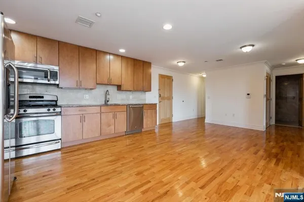 a kitchen with stainless steel appliances granite countertop a stove a sink and a refrigerator