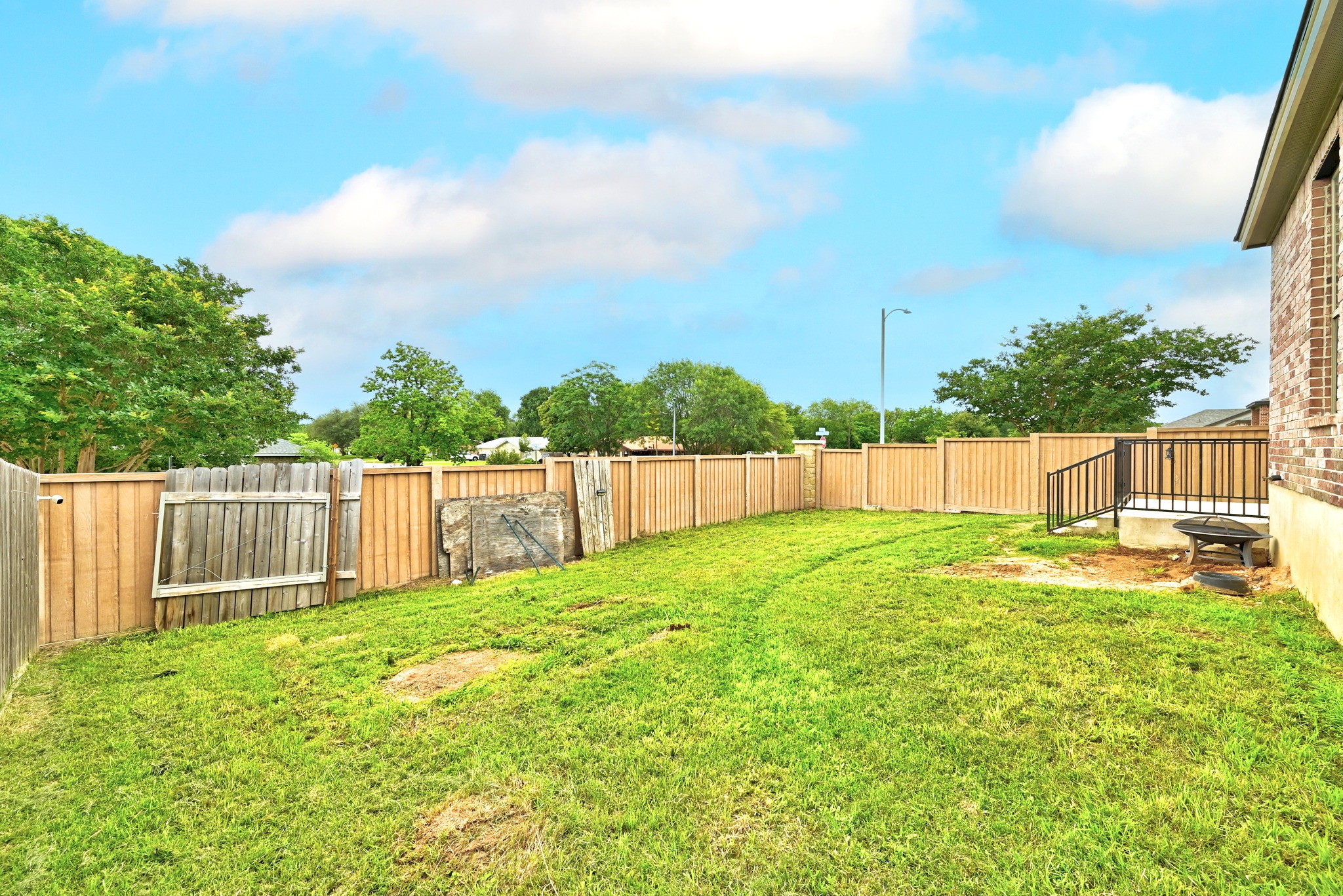 1621 Dragonfly Loop Bastrop, TX 78602 - Photo 26 of 27 Fenced backyard with a grassy area and mature trees