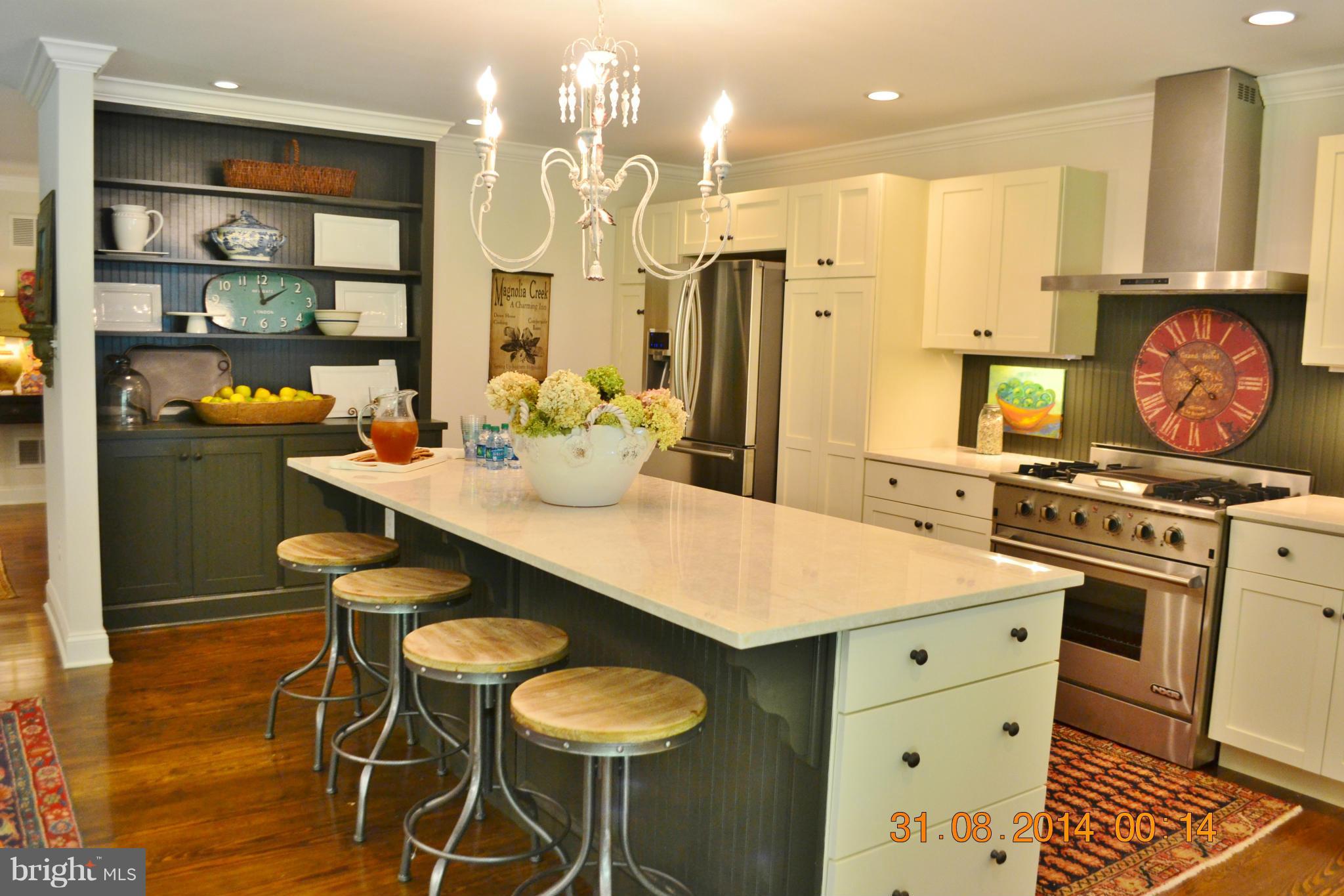 4242 Butler Road Glyndon, MD 21136 - Photo 15 of 29 a kitchen with stainless steel appliances kitchen island granite countertop a table chairs and a refrigerator
