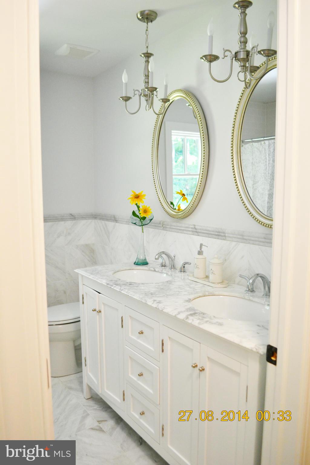 4242 Butler Road Glyndon, MD 21136 - Photo 22 of 29 a bathroom with a granite countertop toilet sink and mirror