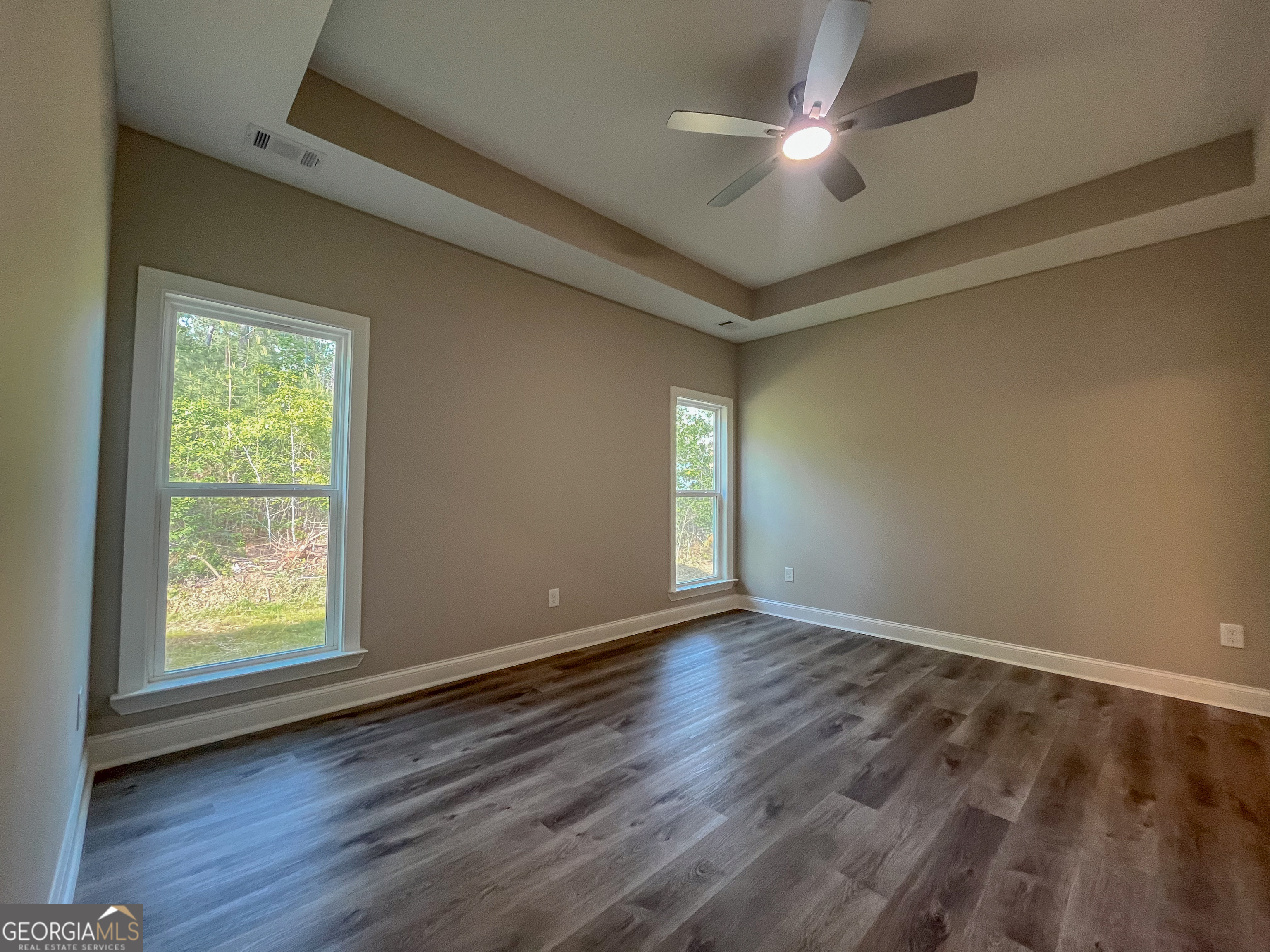 711 Flanders Lane Dublin, GA 31021 - Photo 21 of 49 an empty room with wooden floor and windows