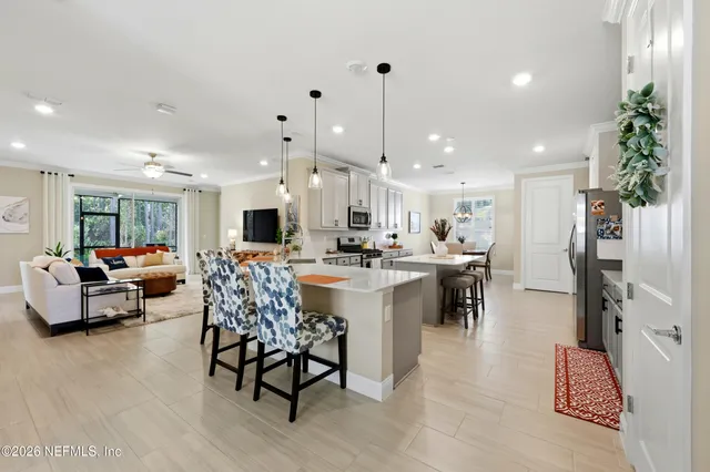 a living room with furniture kitchen view and a chandelier