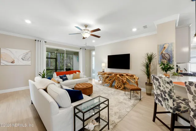 a living room with furniture ceiling fan and a large window