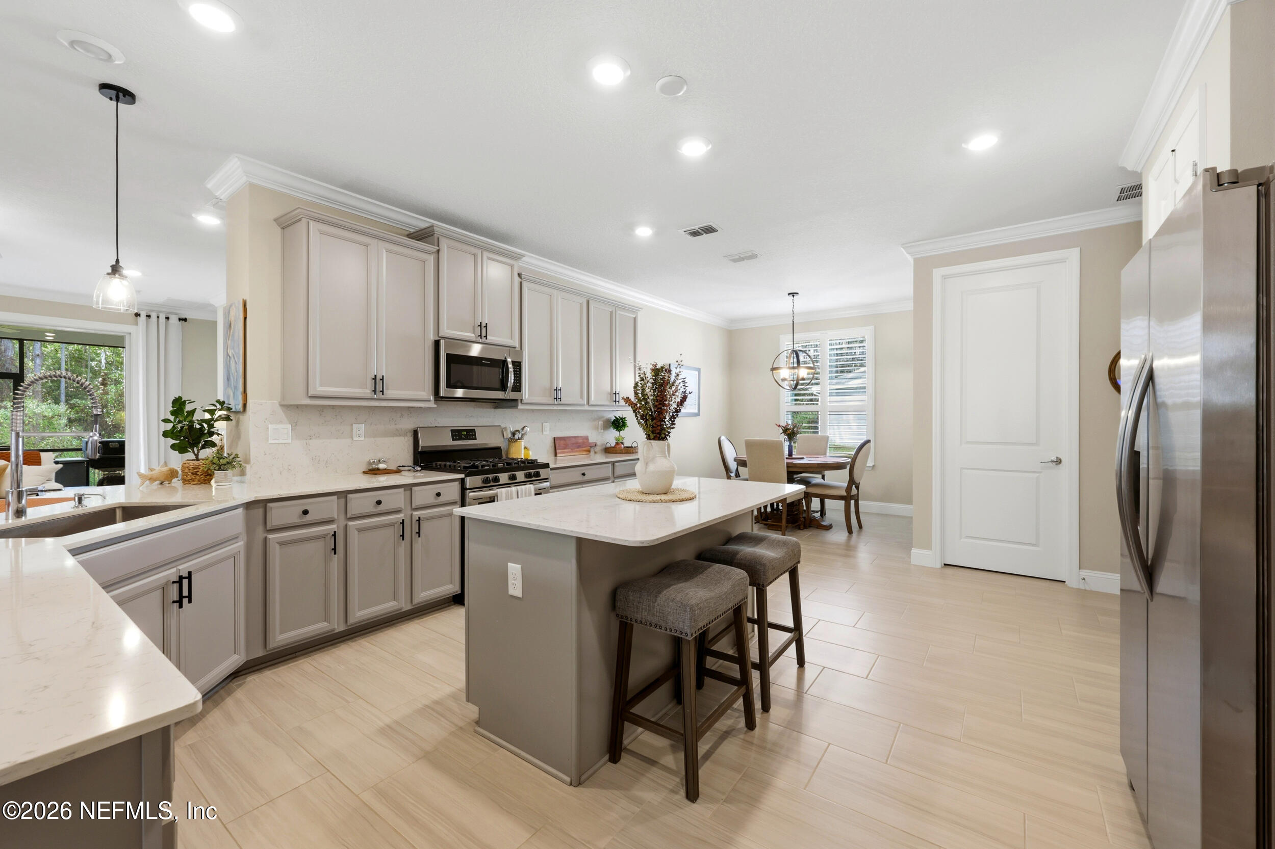 25 Waterbrook Place St. Augustine, FL 32095 - Photo 29 of 55 a kitchen with stainless steel appliances granite countertop a table chairs sink refrigerator and microwave