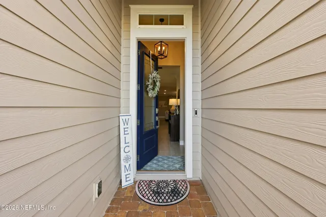 a view of a hallway with wooden floor and a bathroom
