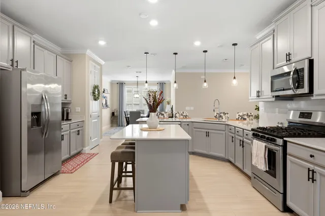 a kitchen with stainless steel appliances a stove a sink a refrigerator a center island and cabinets