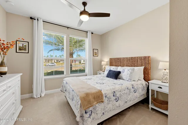 a bedroom with a bed chandelier and a window