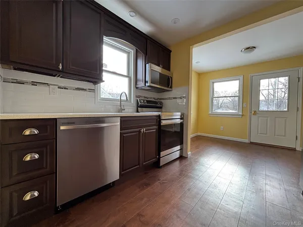 a kitchen with stainless steel appliances granite countertop a stove a sink and a microwave
