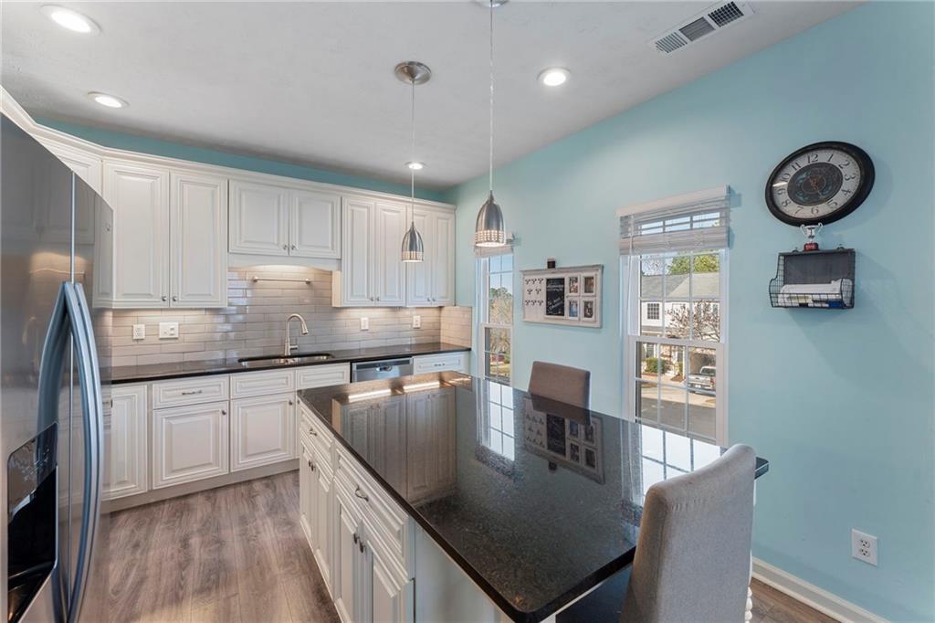 4074 Spring Cove Drive Duluth, GA 30097 - Photo 19 of 48 a kitchen with stainless steel appliances granite countertop a stove top oven a sink a counter space and cabinets