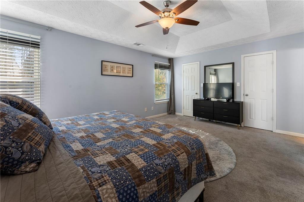 4074 Spring Cove Drive Duluth, GA 30097 - Photo 29 of 48 a bedroom with a bed and a chandelier
