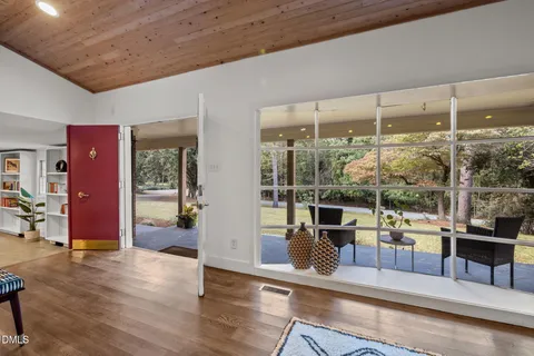 a room with lots of wooden furniture and glass door