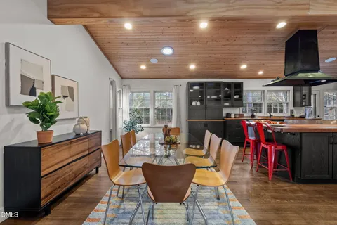 a dining room with stainless steel appliances kitchen island granite countertop a dining table chairs and granite counter tops