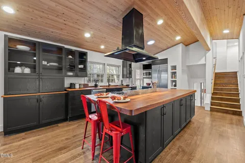 a kitchen with stainless steel appliances granite countertop a kitchen island a stove and a wooden floors