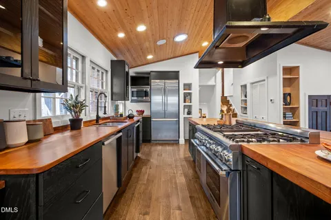 a kitchen with stainless steel appliances granite countertop a sink a stove and a refrigerator