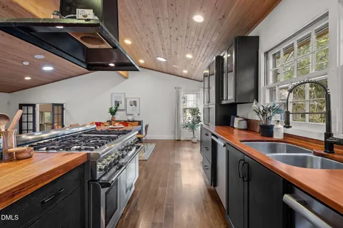 a kitchen with stainless steel appliances granite countertop a sink stove and cabinets