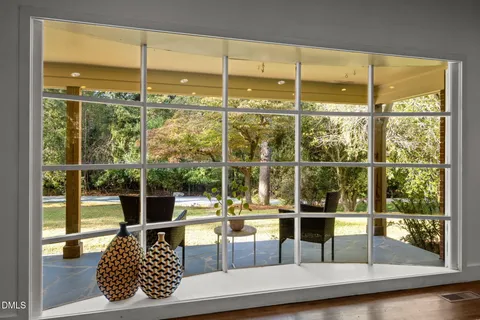 a living room with glass top table and chairs