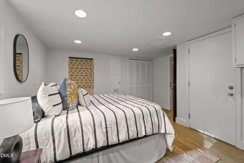 a bedroom with a bed a mirror and a window