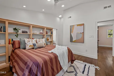 a bedroom with double bed and a painting on the wall