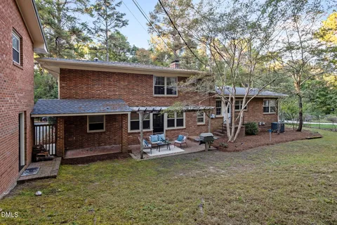 a view of yard from deck with patio