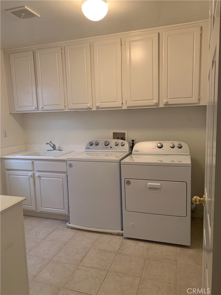 33782 Channel Street Temecula, CA 92592 - Photo 17 of 30 a utility room with cabinets washer and dryer