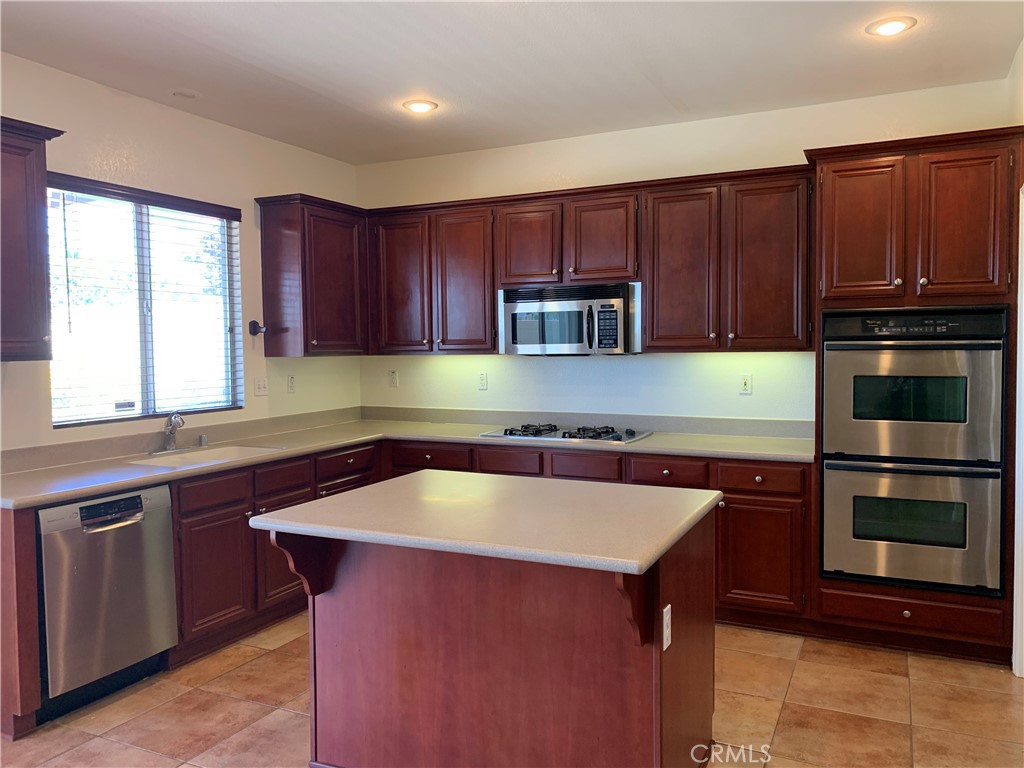33782 Channel Street Temecula, CA 92592 - Photo 5 of 30 a kitchen with wooden cabinets a sink and a stove with wooden floor