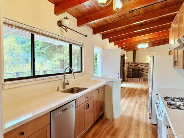 a large kitchen with cabinets a sink and wooden floor