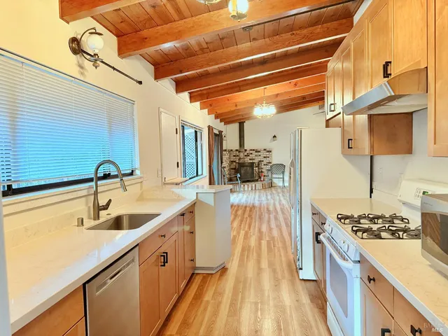 a view of a room with wooden floor a ceiling fan and windows