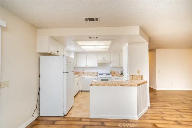 a room with kitchen island a sink a stove a refrigerator and a window