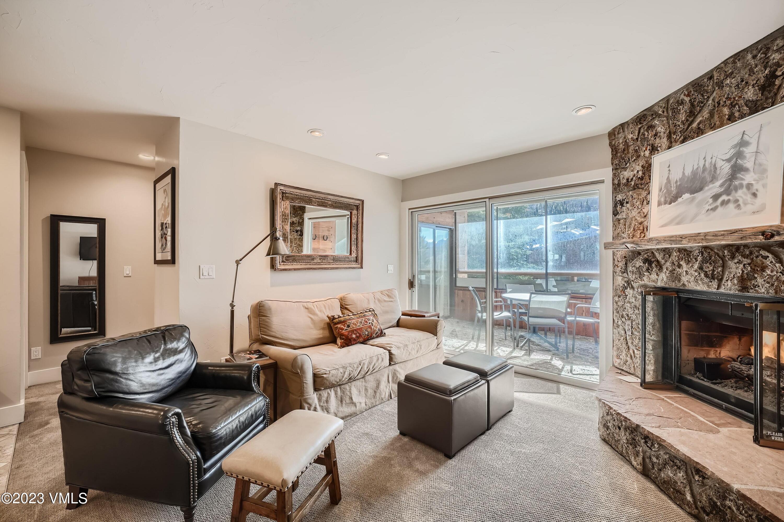 a living room with furniture large window and fireplace