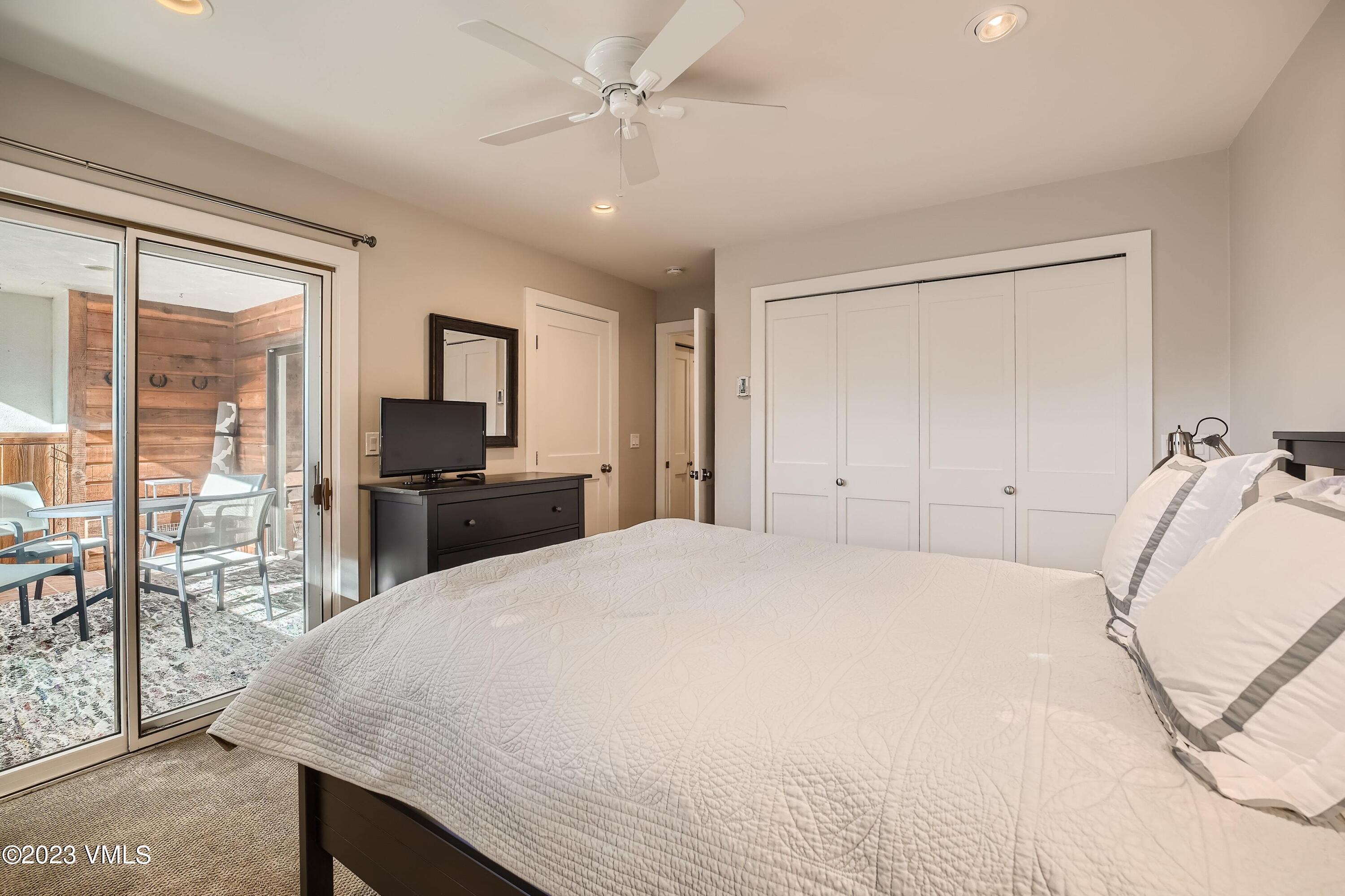 1030 Lions Ridge Loop, Unit 202 Vail, CO 81657 - Photo 13 of 25 a bedroom with a large bed and a chandelier