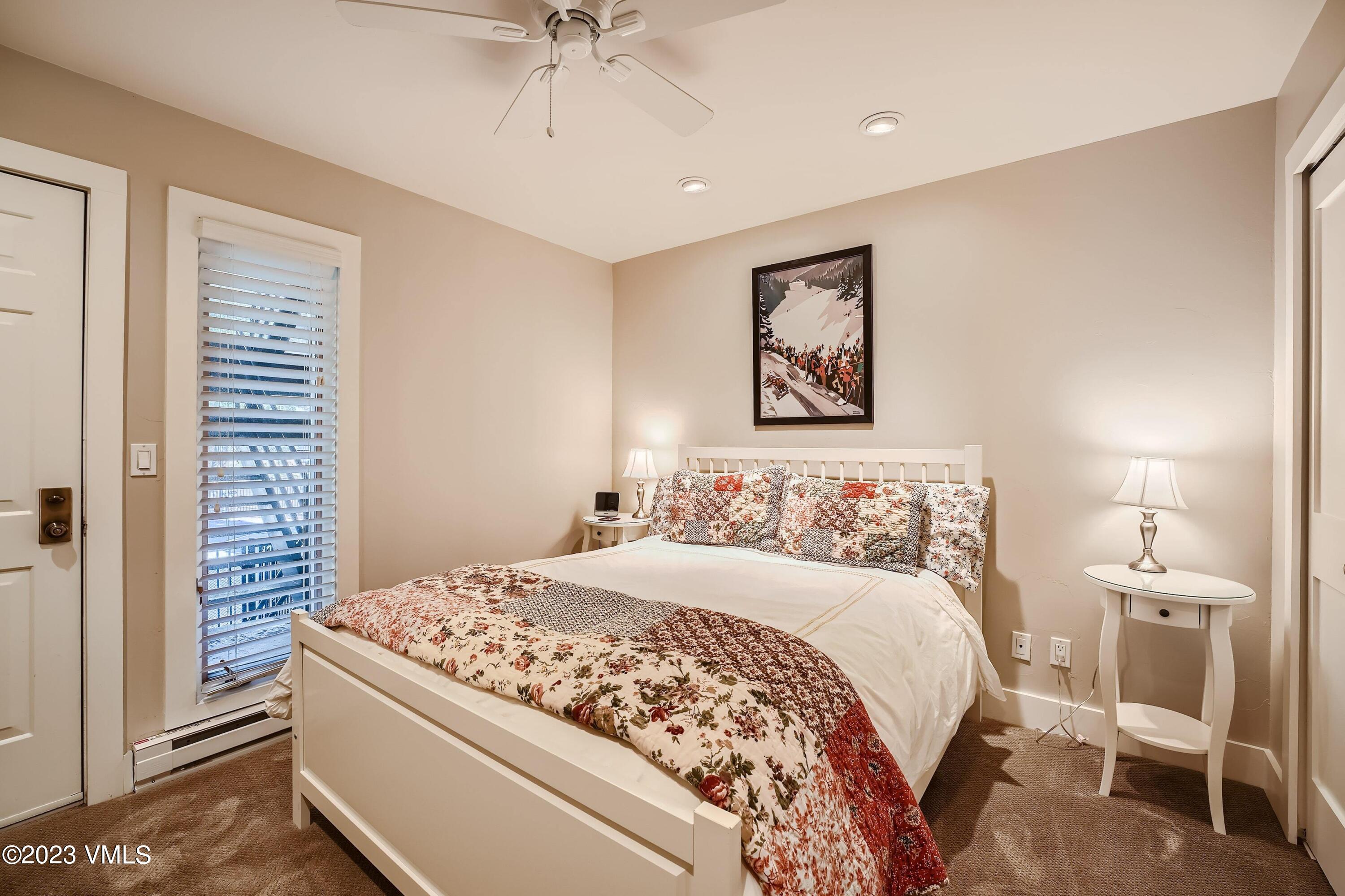 1030 Lions Ridge Loop, Unit 202 Vail, CO 81657 - Photo 15 of 25 a bedroom with a large bed and a chandelier