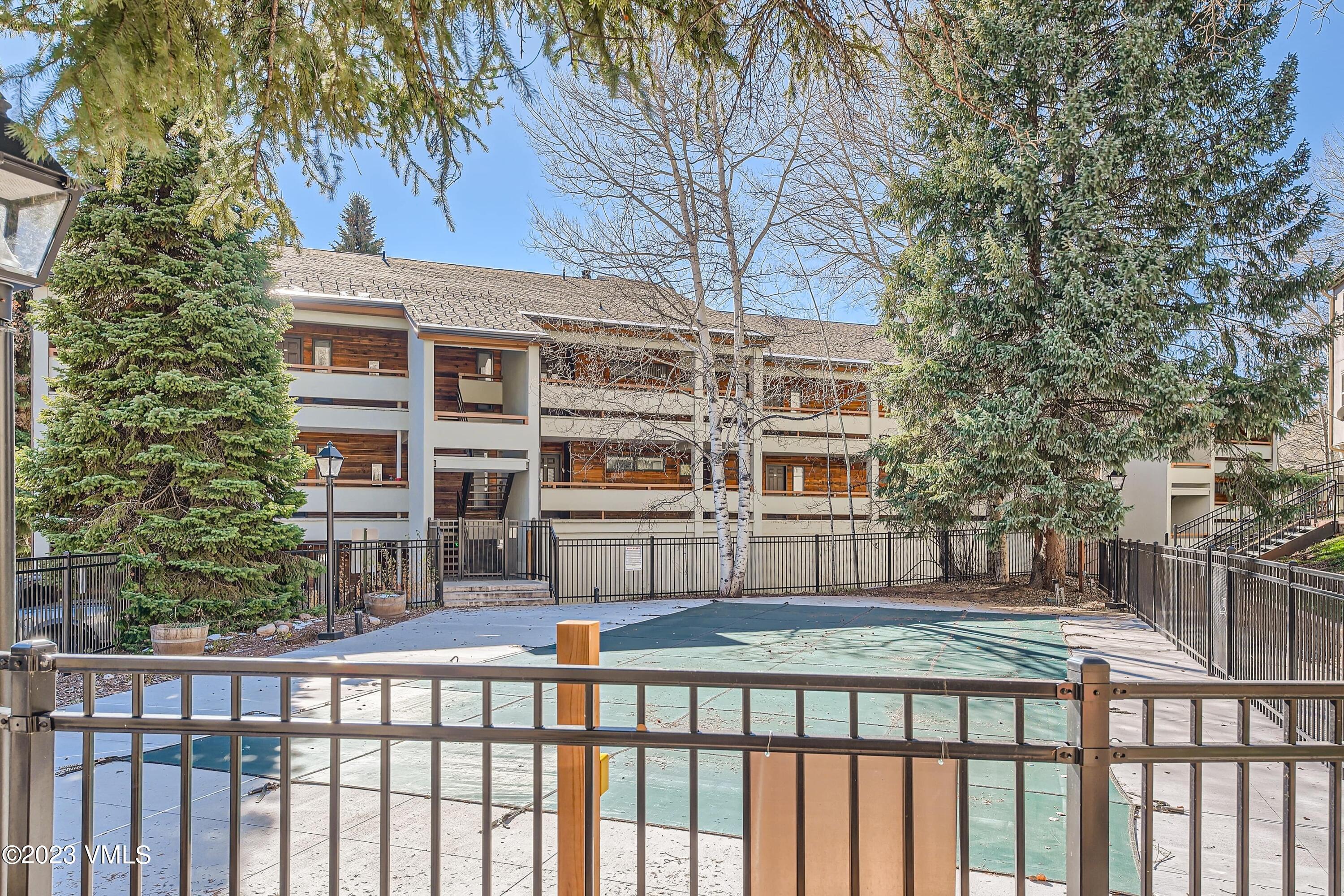 1030 Lions Ridge Loop, Unit 202 Vail, CO 81657 - Photo 22 of 25 a front view of a building with large trees