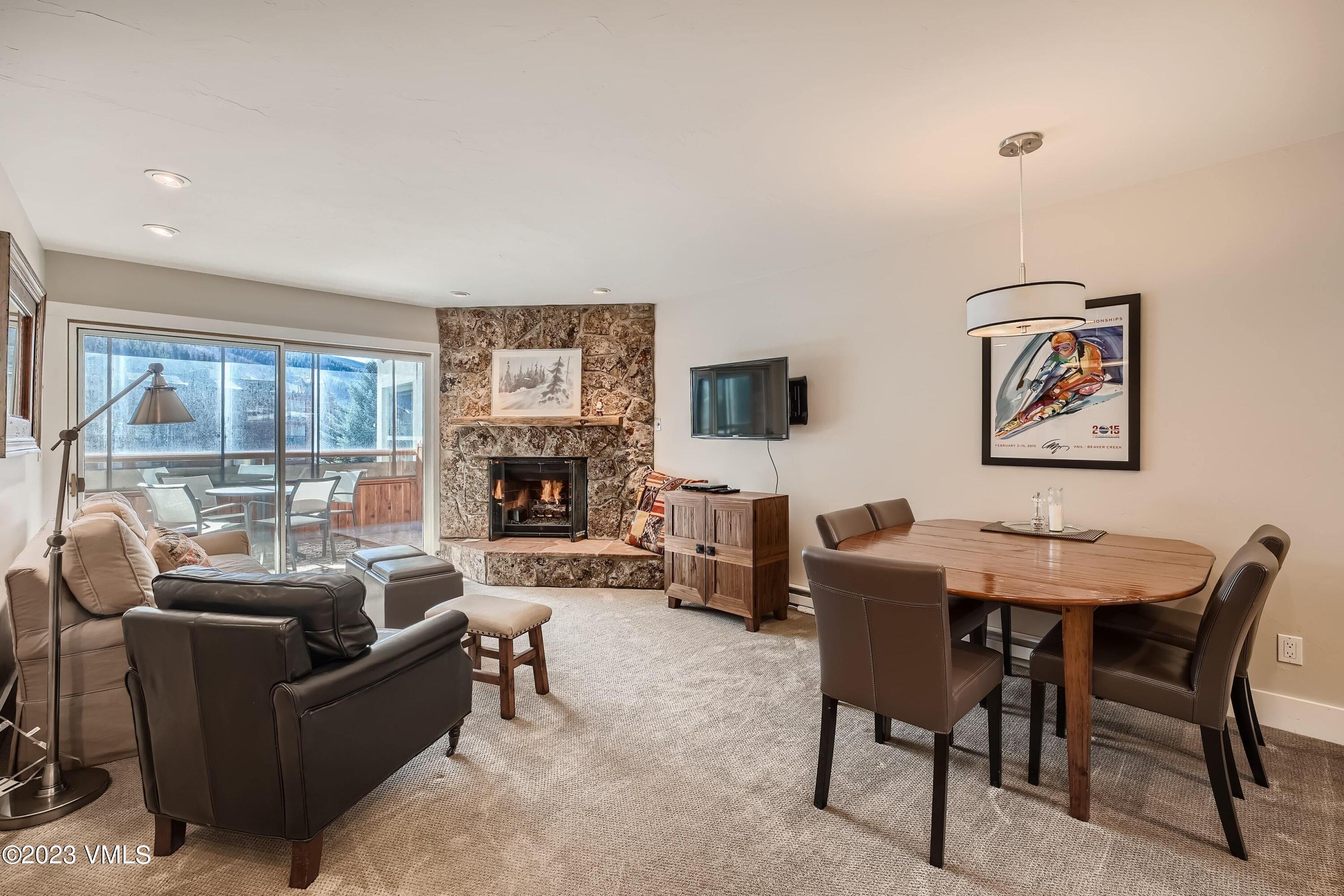 1030 Lions Ridge Loop, Unit 202 Vail, CO 81657 - Photo 3 of 25 a living room with furniture a large window and a fireplace