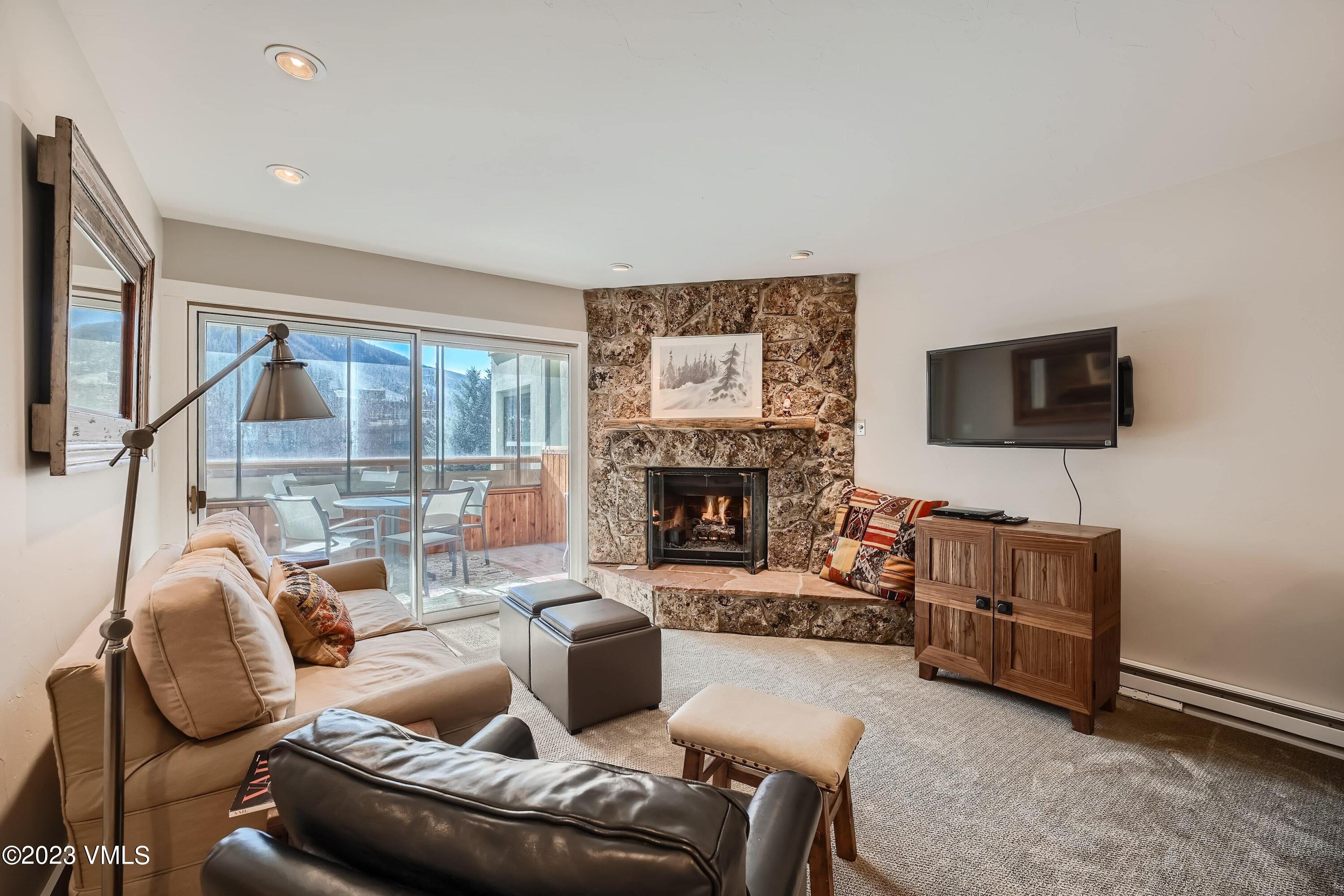 1030 Lions Ridge Loop, Unit 202 Vail, CO 81657 - Photo 4 of 25 a living room with furniture a flat screen tv and a fireplace