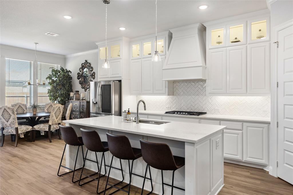 2628 Flycatcher Road Fort Worth, TX 76118 - Photo 11 of 38 Kitchen featuring crown molding, backsplash, white cabinetry, appliances with stainless steel finishes, and light wood-type flooring