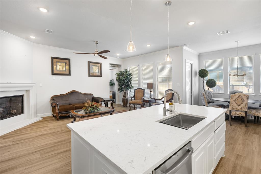 2628 Flycatcher Road Fort Worth, TX 76118 - Photo 37 of 38 Kitchen featuring white cabinets, open floor plan, crown molding, decorative light fixtures, and a kitchen island with sink